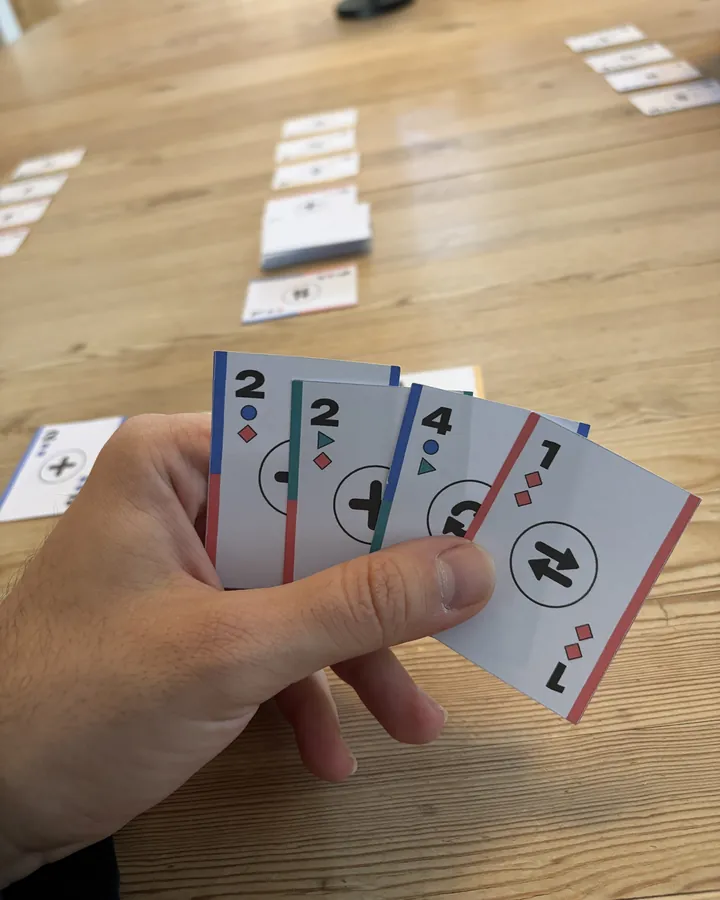 Vier Hey4!-Karten als Fächer in der Hand